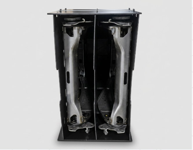 Black returnable container holding two metal control arms on custom solid-HDPE dunnage